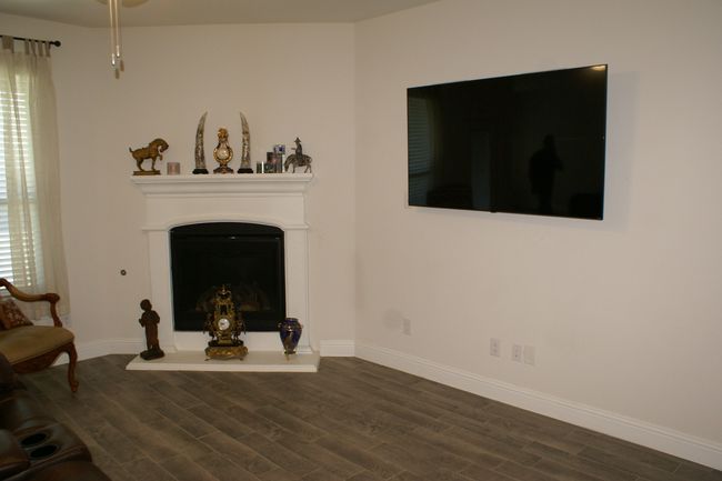Living area featuring baseboards, wood look flooring, and a fireplace with raised hearth | Image 10
