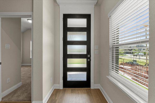 Foyer with modern wood and glass door. | Image 4