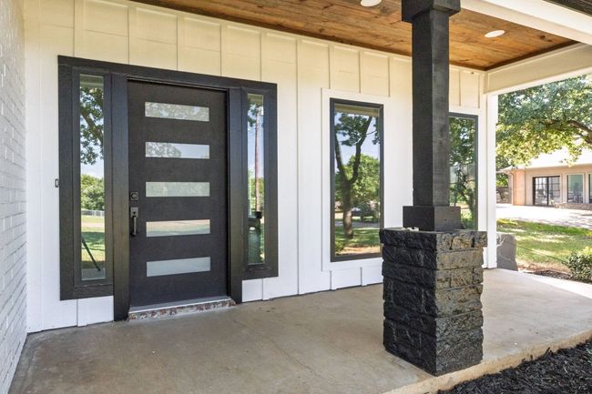 Entrance to property with board and batten siding, french doors, and a porch | Image 5