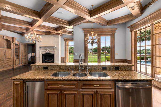 Kitchen featuring stainless steel dishwasher, a chandelier, open floor plan, dark wood-type flooring, and coffered ceiling | Image 21