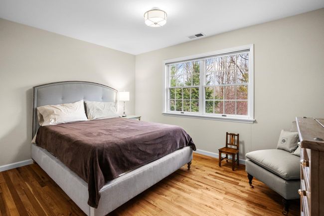 This additional bedroom offers a peaceful retreat with hardwood floors, a large window for abundant natural light, and ample space for a queen bed and additional furnishings—ideal for guests or family. | Image 29