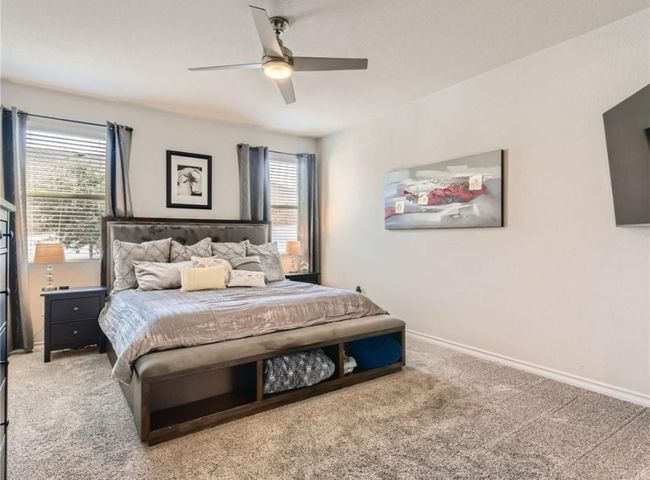 Bedroom with carpet floors, multiple windows, and ceiling fan | Image 9
