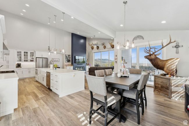 Dining area featuring a towering ceiling, recessed lighting, light wood finished floors, and a chandelier | Image 52