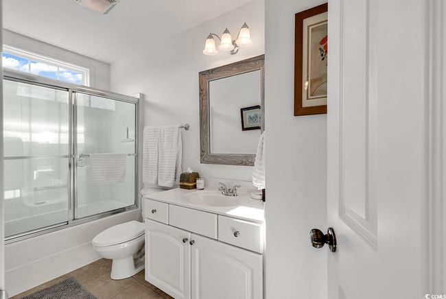 Bedroom featuring light carpet, crown molding, a raised ceiling, and ceiling fan | Image 26
