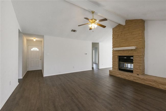 Family Room with two-sided fireplace, vaulted ceiling, and fan. Flooring and fresh white paint, including all cabinet, done in February 2022. | Image 4