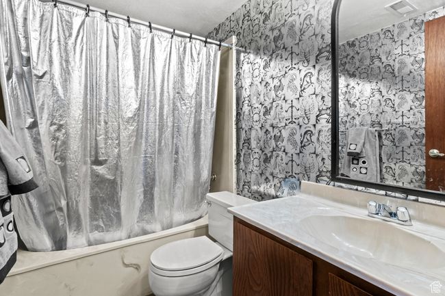Full bath with wallpapered walls, vanity, and shower / tub combo | Image 34