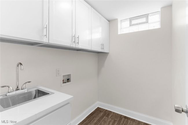 Washroom featuring cabinet space, washer hookup, and dark wood finished floors | Image 36