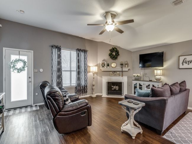 Living area with ceiling fan, wood finished floors, and baseboards | Image 7