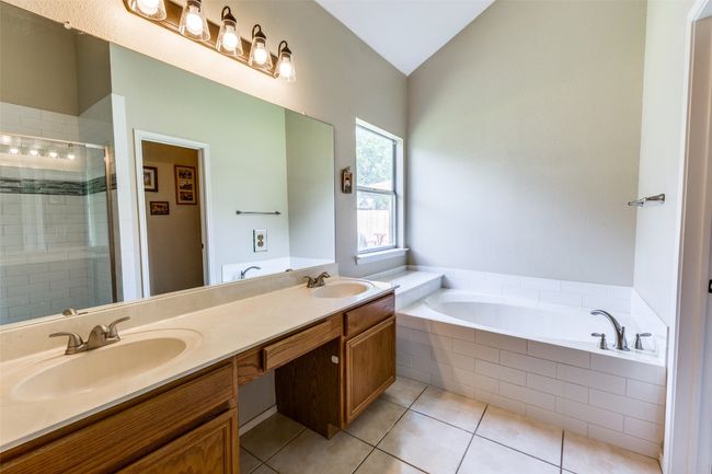 Bathroom featuring a stall shower, a bath, vaulted ceiling, tile patterned floors, and double vanity | Image 14