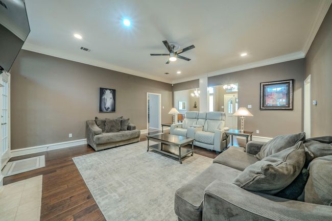 Living room featuring ceiling fan, ornamental molding, dark wood-style floors, and recessed lighting | Image 6