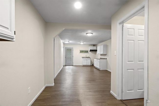 Hallway with dark wood finished floors and baseboards | Image 13