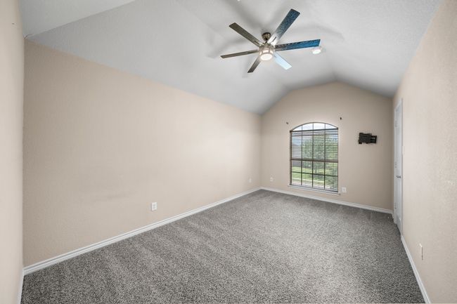 Carpeted empty room with baseboards, lofted ceiling, and ceiling fan | Image 30