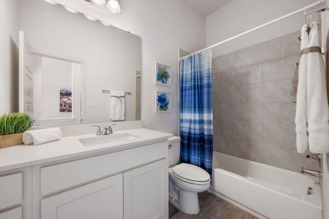 Bathroom with vanity, shower / bathtub combination with curtain, toilet, and wood finished floors | Image 25
