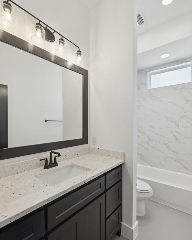 Full bathroom featuring vanity, tiled shower / bath, and toilet | Image 26