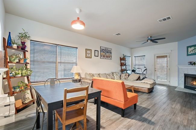 A large archway from the kitchen overlooks the dining and living with a corner fireplace with tile surround. | Image 14