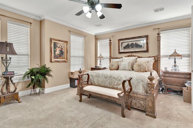 The lush and private primary suite is downstairs, with plush carpeting and plenty of windows for natural light. | Image 14