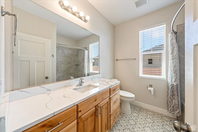 Full bathroom featuring toilet, baseboards, a healthy amount of sunlight, and visible vents | Image 33