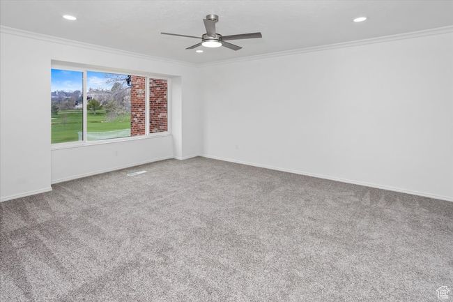 Spare room featuring carpet flooring, baseboards, ceiling fan, and ornamental molding | Image 17