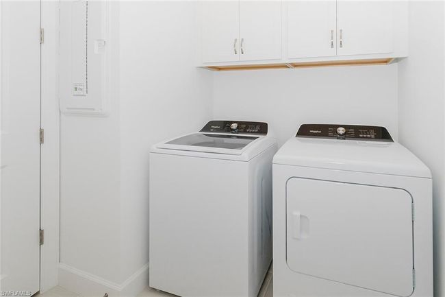 Laundry area with washer and clothes dryer, cabinet space, and electric panel | Image 7
