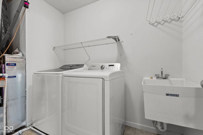 Laundry area featuring water heater and separate washer and dryer w/utility sink | Image 25