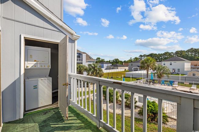 Balcony featuring stacked washer / dryer and a residential view | Image 22