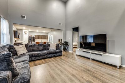 Living room featuring a high ceiling and light wood-type flooring | Image 3