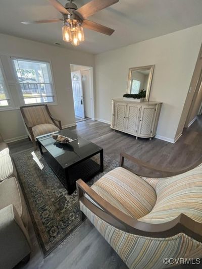 Living room with dark hardwood / wood-style flooring and ceiling fan | Image 2