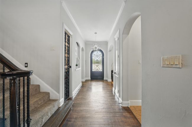 Enter the home thorough the beautiful custom door onto hammered down wood stained floors. | Image 5