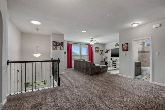 Living room with carpet flooring, baseboards, and a ceiling fan | Image 15