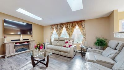 Living room w/ lofted ceiling & skylight | Image 3