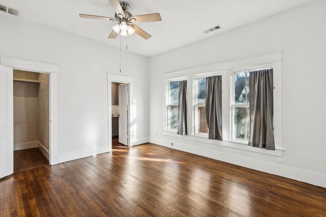 Unfurnished bedroom with wood-type flooring, baseboards, a spacious closet, and a ceiling fan | Image 9
