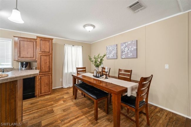 Dining room with dark wood-type flooring and crown molding | Image 11