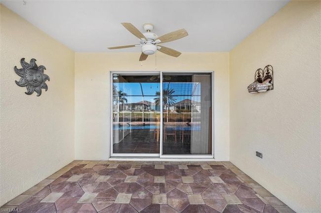 Doorway to property with stucco siding and ceiling fan | Image 28