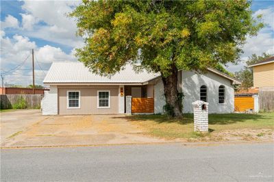 View of front of property featuring a front lawn and large tree. | Image 1