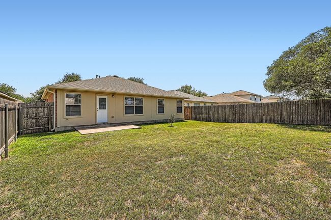 Back of house featuring a lawn, a patio, stucco siding, and a fenced backyard | Image 25