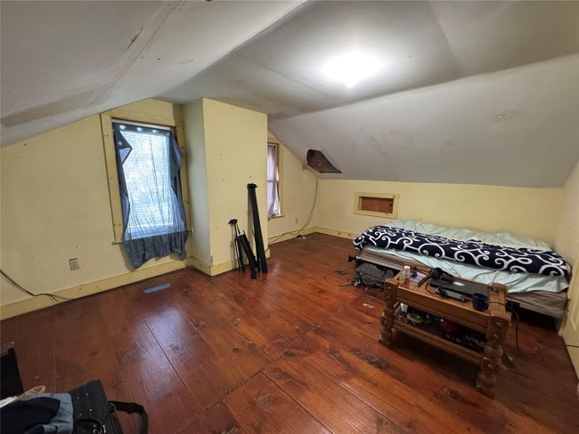 Bedroom featuring hardwood / wood-style floors, lofted ceiling, and baseboards | Image 24