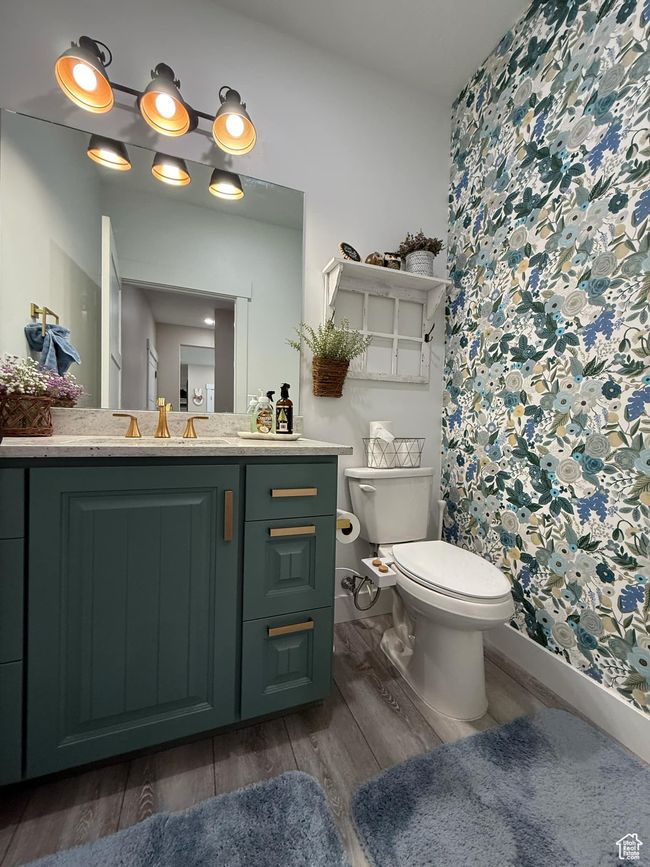 Full bath with toilet, a shower with shower curtain, wood finished floors, and vanity | Image 48