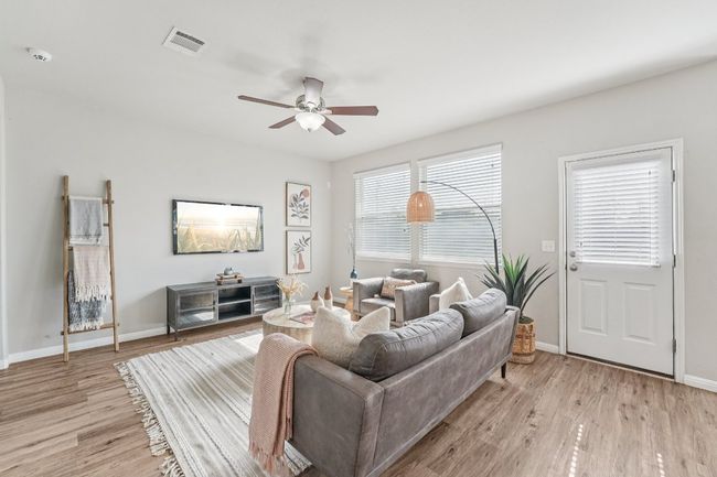 Living area with a ceiling fan and light wood-style floors | Image 8