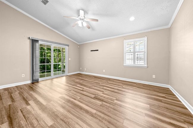 Empty room featuring a ceiling fan, wood finished floors, and a wealth of natural light | Image 29