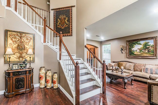 Staircase with wood finished floors and arched walkways | Image 17