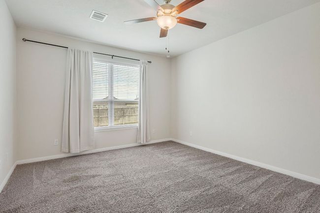 Oversized primary suite offers restful retreat with natural light and upgraded fan. | Image 15