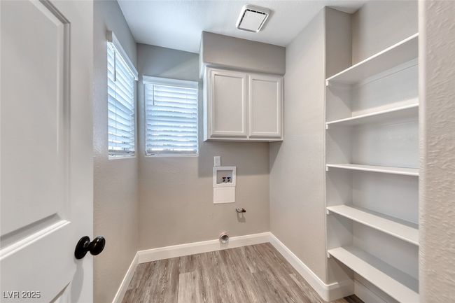 Laundry area featuring wood finished floors, washer hookup, hookup for a gas dryer, and cabinet space | Image 16