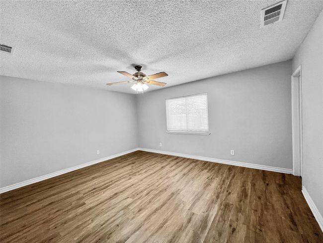 Unfurnished room with wood finished floors, ceiling fan, and a textured ceiling | Image 9