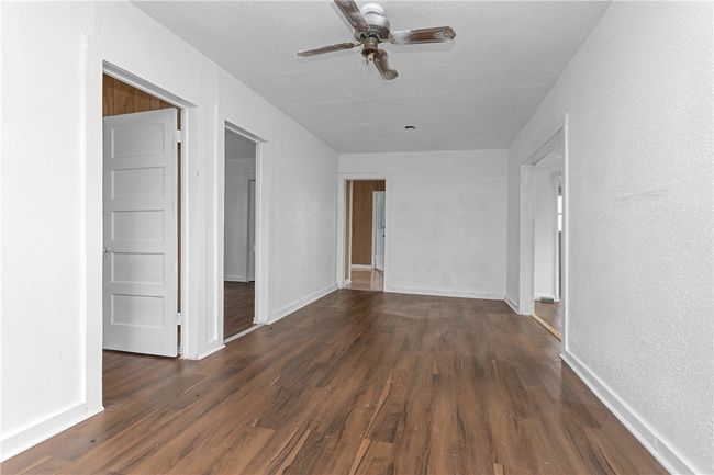 Spare room with a ceiling fan and dark wood-type flooring | Image 21