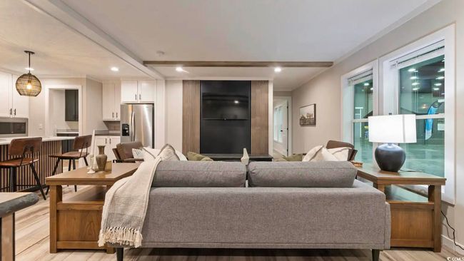 Living room with light wood-type flooring, recessed lighting, beamed ceiling, and ornamental molding | Image 4