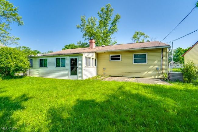 Rear view of house featuring a chimney, a yard, and central AC | Image 5
