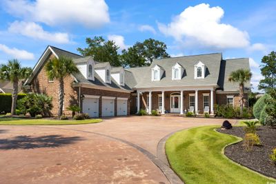 New england style home featuring covered porch, a front yard, and a garage | Image 2