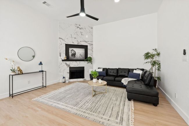 Living room with baseboards, waterproof finished floors, visible vents, and ceiling fan | Image 4