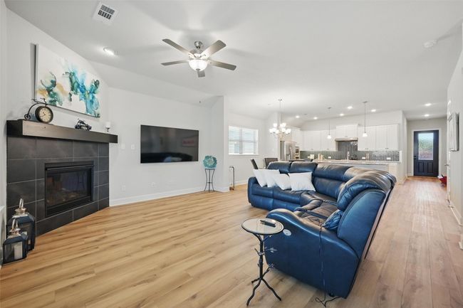 Living room featuring recessed lighting, light wood-type flooring, baseboards, ceiling fan, and a tiled fireplace | Image 6