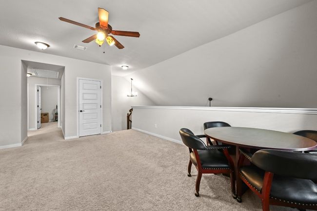 Den/game rm or office with a ceiling fan, attic access, carpet floors, and vaulted ceiling | Image 20